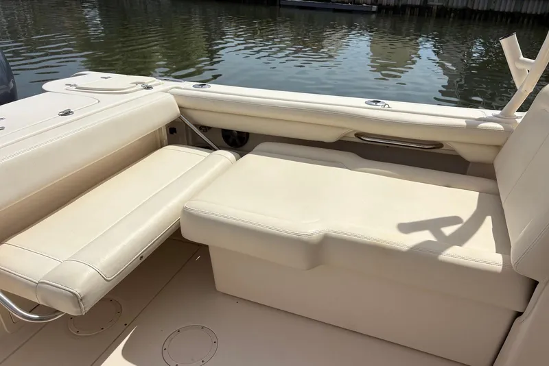 Slide: The Image of 2019 Grady-White Freedom 275 boat interior with beige seating by the water. - 18