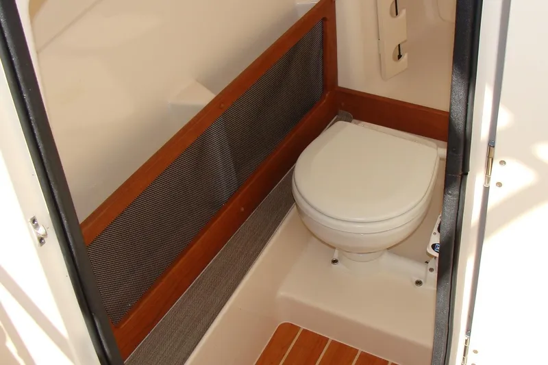 Slide: The Image of 2019 Grady-White Freedom 275 boat interior with compact marine toilet. - 27