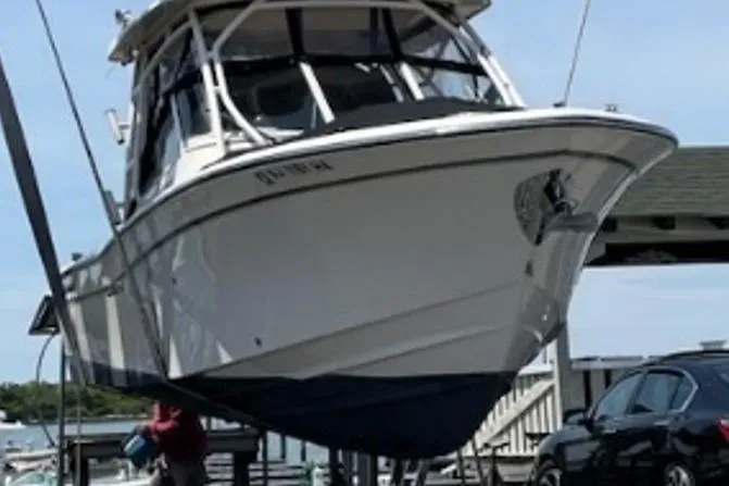 Slide: The Image of 2019 Grady-White Freedom 275 boat on lift, dockside view. - 29