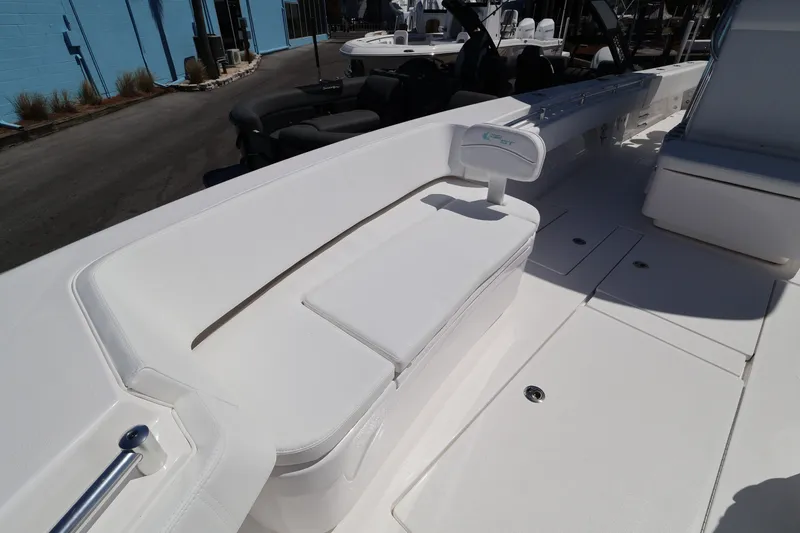 Slide: The Image of 2026 Contender 32 ST boat interior with white seating and deck, docked outdoors. - 22