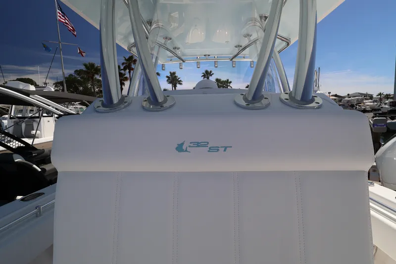 Slide: The Image of 2026 Contender 32 ST boat interior with rod holders and logo, docked under clear sky. - 32