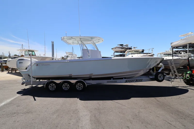 Slide: The Image of 2026 Contender 32 ST boat on trailer, docked with flags and palm trees in background. - 63