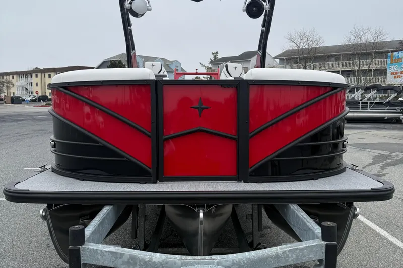 Slide: The Image of 2026 Berkshire 23RFX STS pontoon boat, red and black design, parked on trailer. - 3