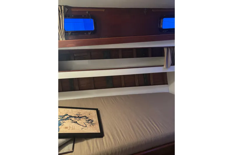 Slide: The Image of 1962 Kettenburg Sloop interior with sink, porthole, and storage cabinets. - 13