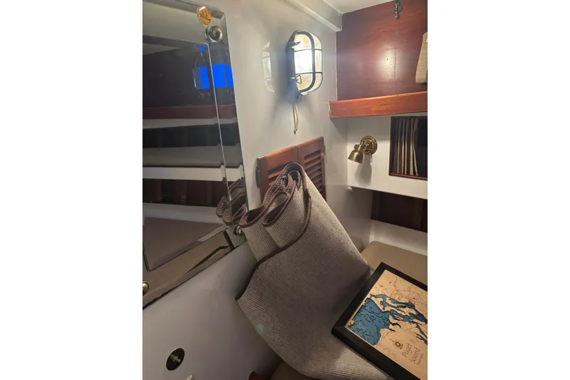 Slide: The Image of 1962 Kettenburg Sloop sailboat cockpit with blue tarp cover, docked at marina. - 17