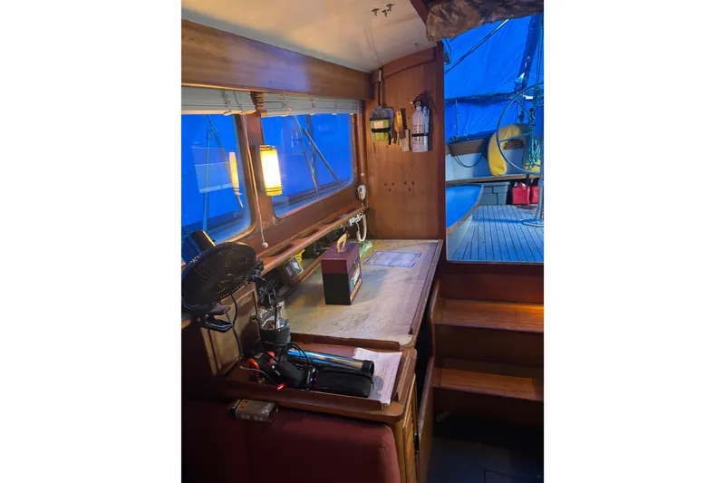 Slide: The Image of Interior of a 1962 Kettenburg Sloop with wooden furnishings and red seating. - 6