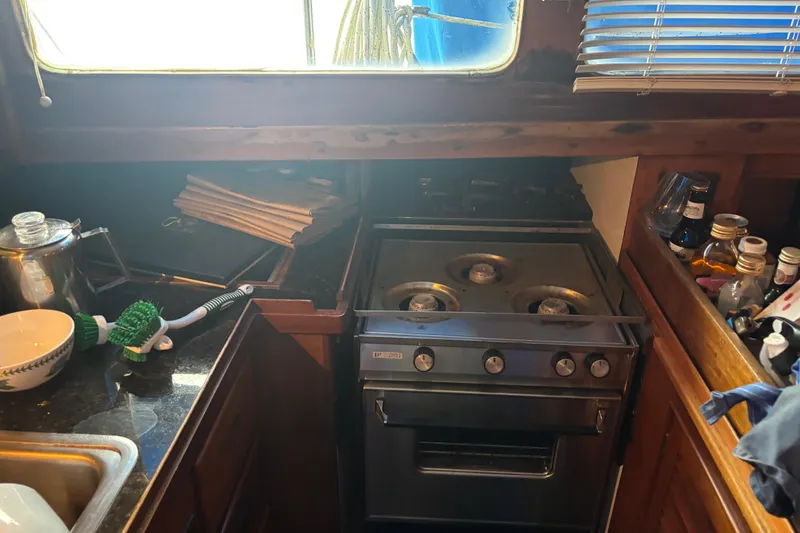 Slide: The Image of Interior of a 1962 Kettenburg Sloop with wooden furnishings and cozy seating. - 8