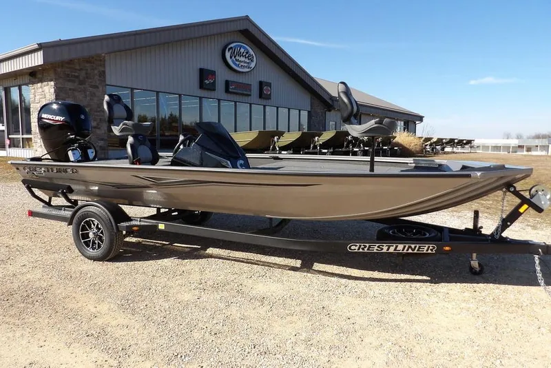 The Image of 2026 Crestliner XF 189 boat on trailer outside dealership, featuring Mercury engine. - 1