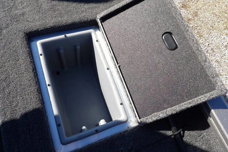Slide: The Image of Open storage compartment in 2026 Crestliner XF 189 boat, featuring carpeted lid and interior. - 21
