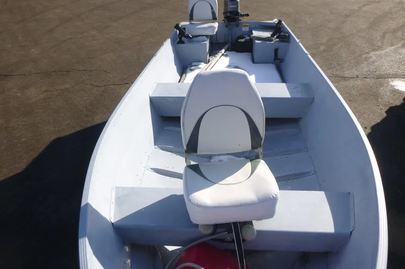 Slide: The Image of 2010 G3 Guide V16 XT boat with white seating and motor, parked on pavement. - 5