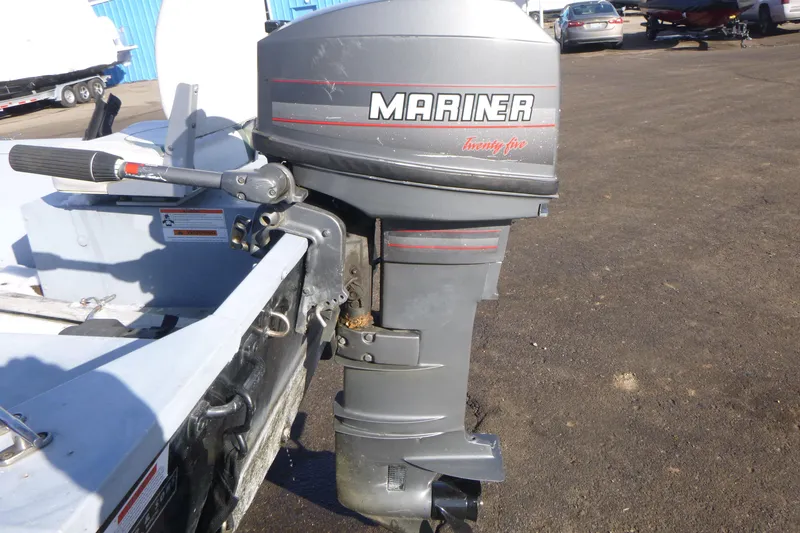 Slide: The Image of Outboard motor on a 2010 G3 Guide V16 XT boat, parked on asphalt. - 6