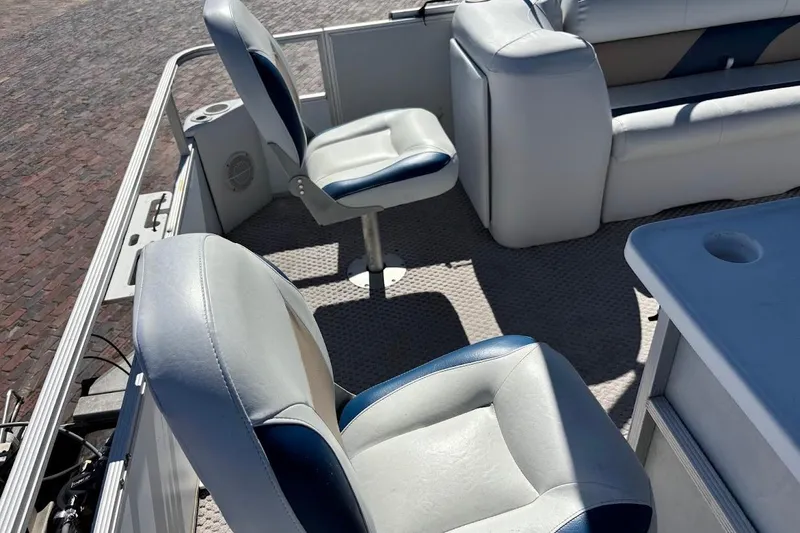 Slide: The Image of Interior of a 2004 Crest 2100 boat with cushioned seating and table. - 13