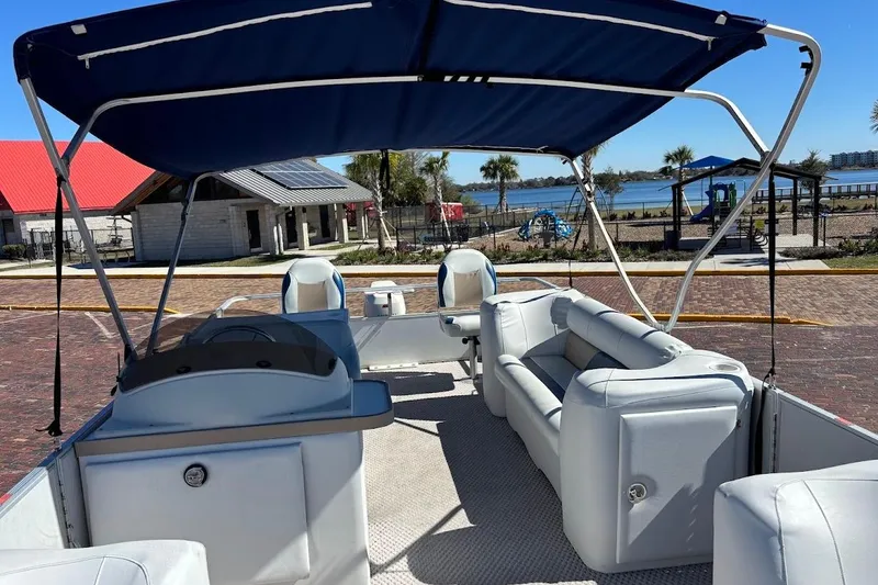 Slide: The Image of 2004 Crest 2100 boat with canopy, docked near a scenic waterfront park. - 18