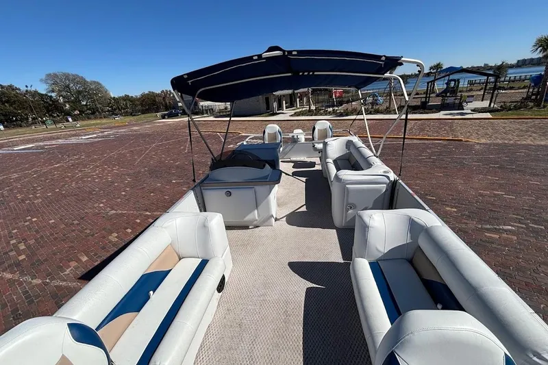 Slide: The Image of 2004 Crest 2100 pontoon boat with spacious seating and canopy on a sunny day. - 21