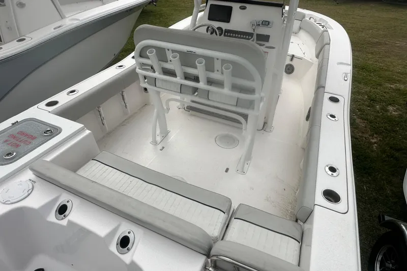 Slide: The Image of 2023 Sea Fox 228 Commander boat interior with seating and console, docked on grass. - 14