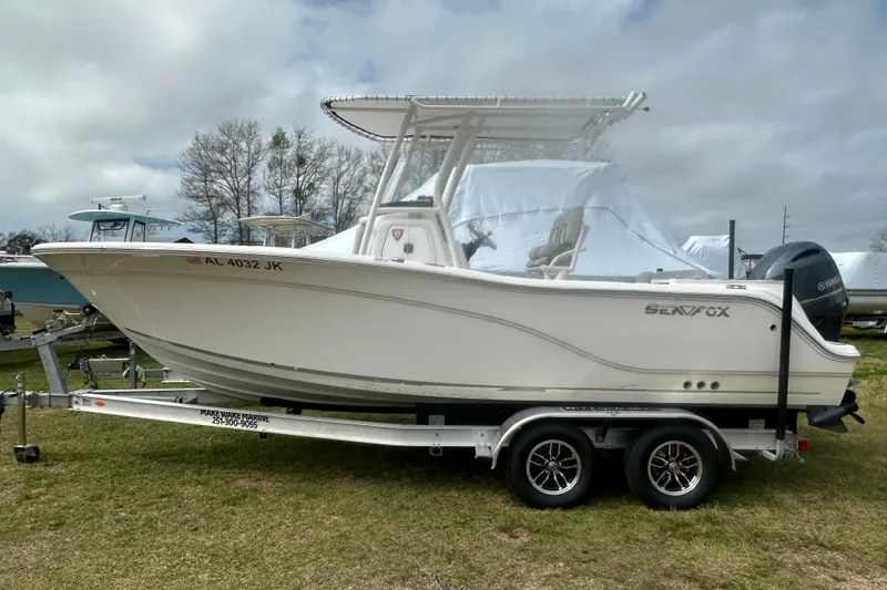 Slide: The Image of 2023 Sea Fox 228 Commander boat on trailer, side view, outdoors. - 30