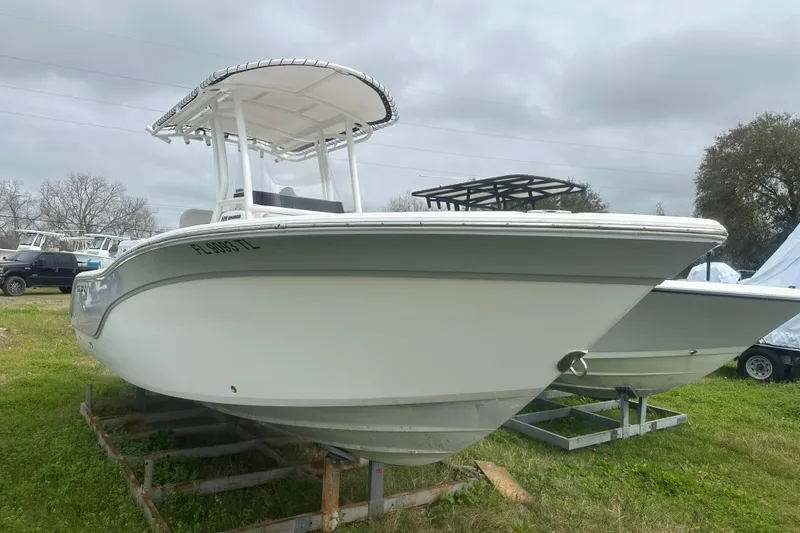 Slide: The Image of 2023 Sea Fox 228 Commander boat on display, parked on grass under cloudy skies. - 6