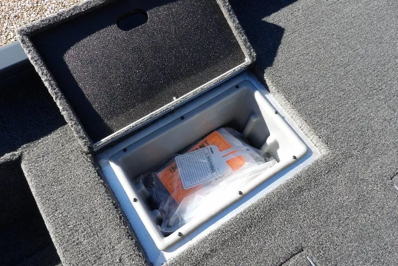 Slide: The Image of Open storage compartment in 2026 Crestliner XFC 189 boat, showing safety equipment inside. - 15