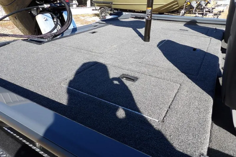 Slide: The Image of 2026 Crestliner XFC 189 boat deck with carpeted surface and storage compartments. - 9