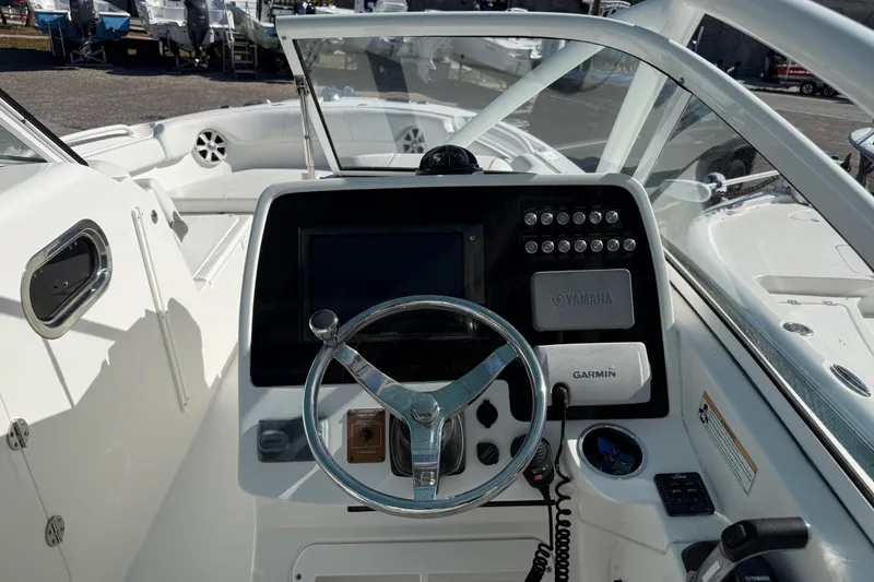 Slide: The Image of 2017 Edgewater 248CX Crossover boat dashboard with steering wheel and navigation controls. - 6