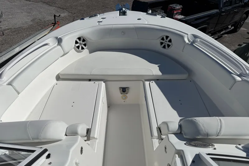 Slide: The Image of 2017 Edgewater 248CX Crossover boat interior with white seating and storage compartments. - 8