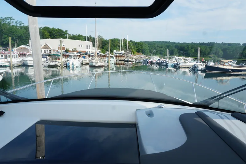 Slide: The Image of 2023 Pursuit OS 355 Offshore yacht docked at a marina with surrounding boats. - 13