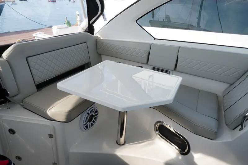 Slide: The Image of 2023 Pursuit OS 355 Offshore boat interior with gray seating and white table. - 14
