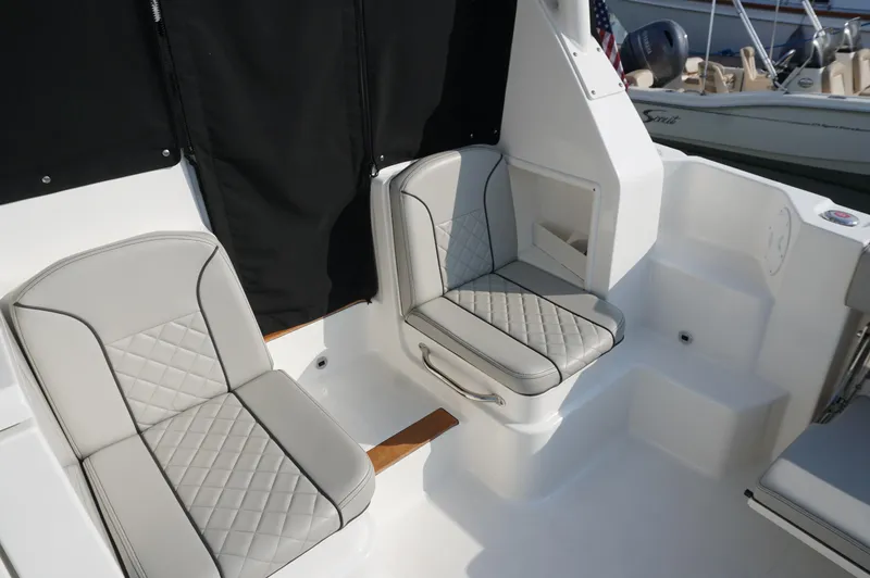 Slide: The Image of 2023 Pursuit OS 355 Offshore boat interior with cushioned seating and storage compartment. - 17
