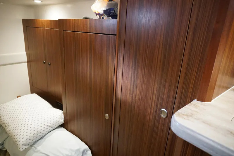 Slide: The Image of 2023 Pursuit OS 355 Offshore cabin with wooden cabinets and cozy bedding. - 34