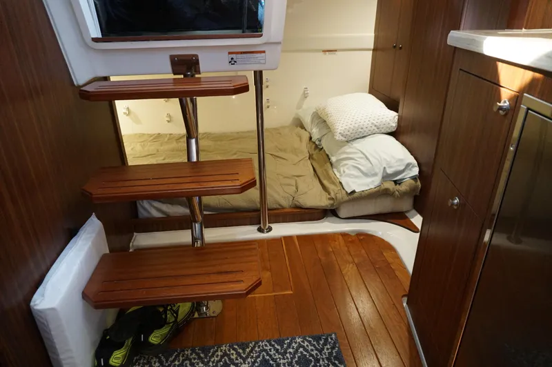 Slide: The Image of 2023 Pursuit OS 355 Offshore cabin interior with wooden steps and cozy bed. - 36