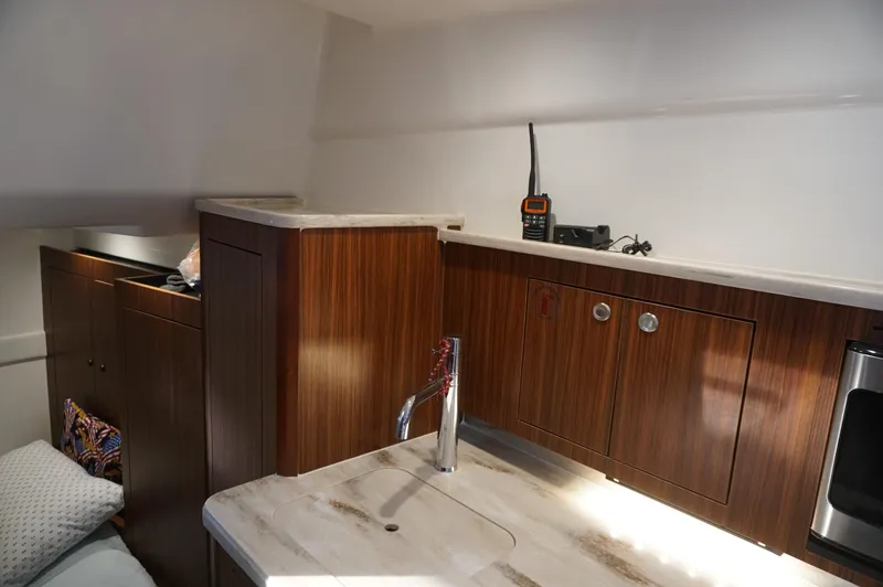 Slide: The Image of 2023 Pursuit OS 355 Offshore cabin interior with wood cabinetry and modern amenities. - 40