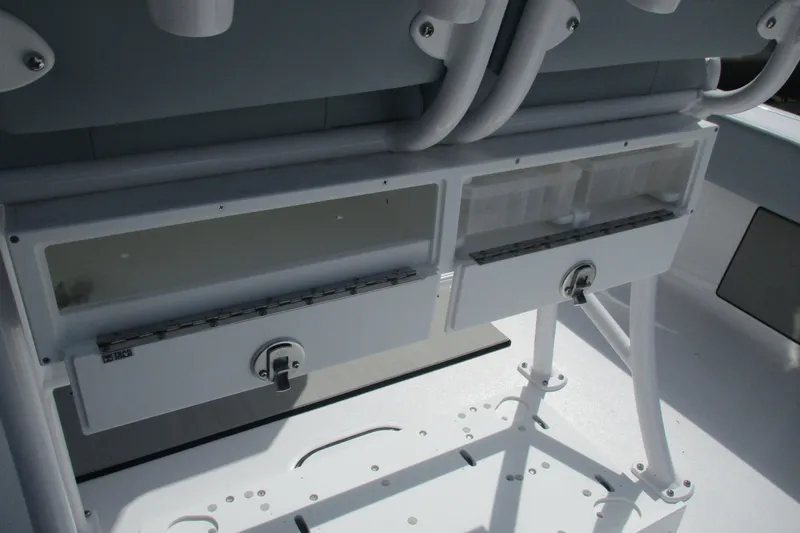 Slide: The Image of 2026 Sportsman Masters 247 Bay Boat storage compartments with secure latches and rod holders. - 7