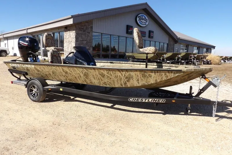 The Image of 2026 Crestliner XFC 189 fishing boat on trailer, parked outside a marine center. - 1