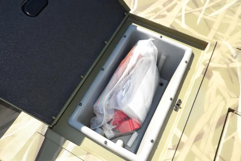 Slide: The Image of Open storage compartment in 2026 Crestliner XFC 189 boat, containing packaged items. - 20