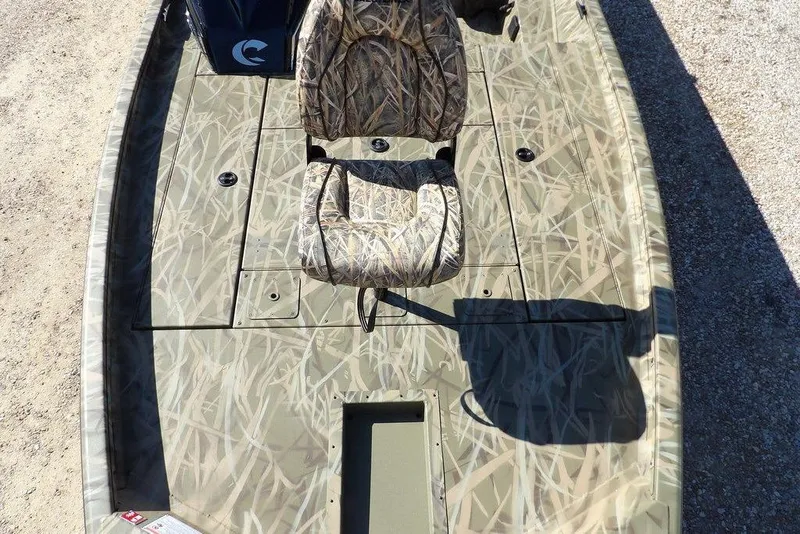 Slide: The Image of 2026 Crestliner XFC 189 boat with camouflage seating and deck, parked on gravel. - 27