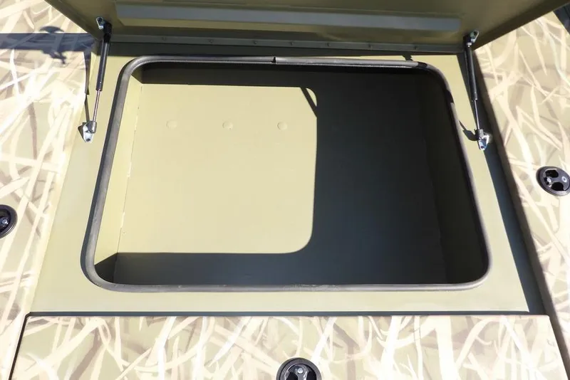 Slide: The Image of Open storage compartment on 2026 Crestliner XFC 189 boat, featuring camo design. - 28