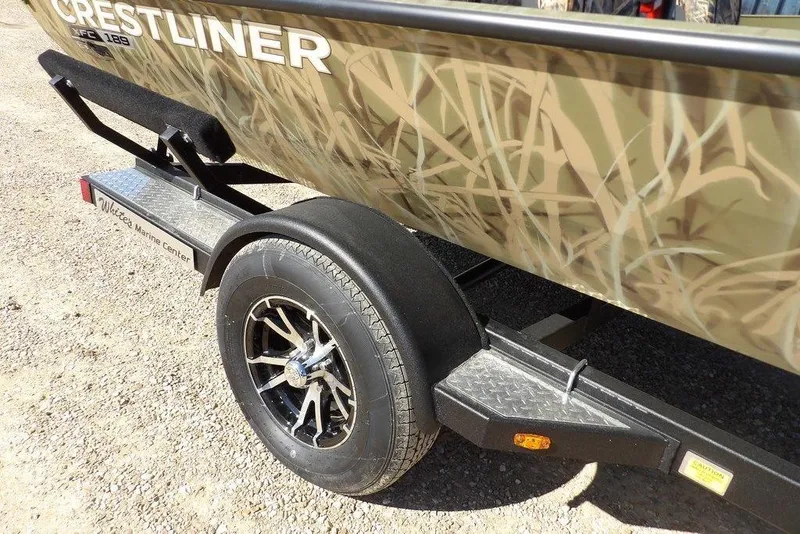 Slide: The Image of 2026 Crestliner XFC 189 boat on trailer with camouflage design and stylish wheel. - 41
