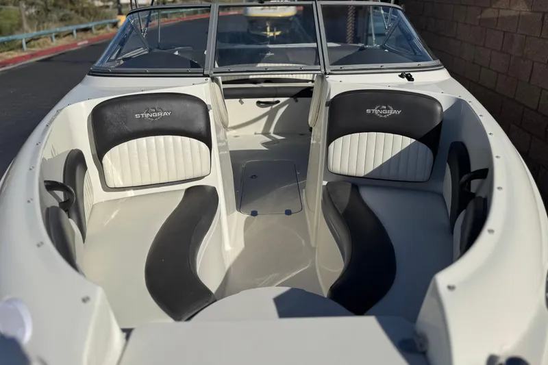Slide: The Image of 2018 Stingray 208 LS boat interior with black and white seating, open bow design. - 10