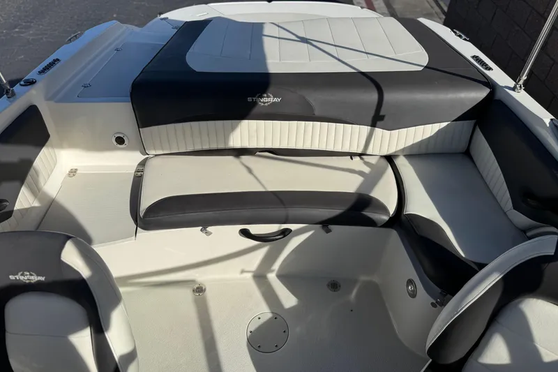 Slide: The Image of 2018 Stingray 208 LS boat interior with black and white seating. - 19