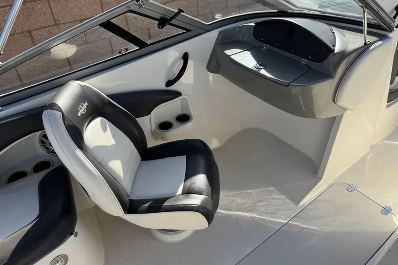 Slide: The Image of 2018 Stingray 208 LS boat interior with black and white seating and dashboard. - 22