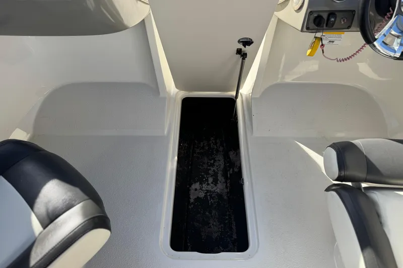 Slide: The Image of 2018 Stingray 208 LS boat interior with storage compartment and seating. - 23
