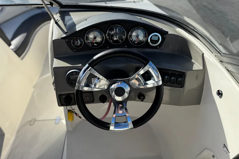 Slide: The Image of Steering wheel and dashboard of 2018 Stingray 208 LS boat, featuring gauges and controls. - 25