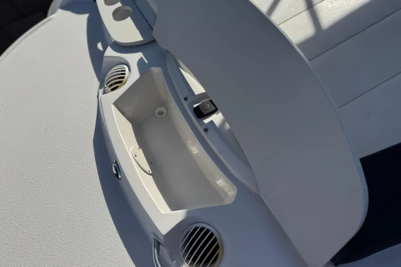 Slide: The Image of 2018 Stingray 208 LS boat interior detail with cup holders and storage compartment. - 7