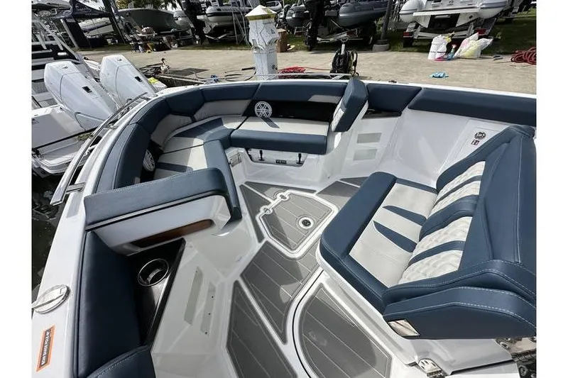 Slide: The Image of 2026 Monterey Elite 30 OB boat interior with blue and white seating, docked at marina. - 6