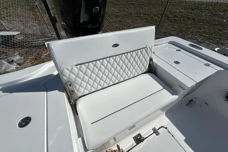 Slide: The Image of 2026 Sportsman Masters 267OE Bay Boat with white cushioned seating and storage compartments. - 12