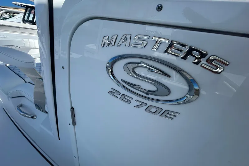 Slide: The Image of 2026 Sportsman Masters 267OE Bay Boat, sleek design with chrome logo detailing. - 16