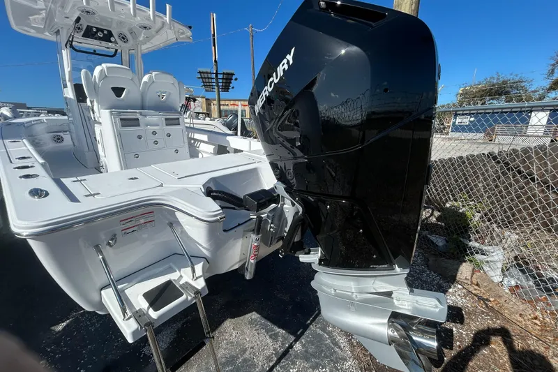 Slide: The Image of 2026 Sportsman Masters 267OE Bay Boat with Mercury outboard engine, docked outdoors. - 17