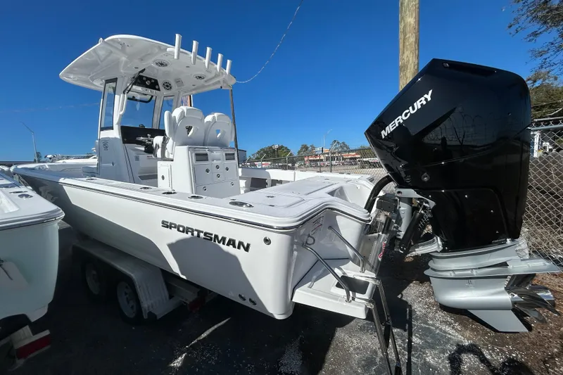 Slide: The Image of 2026 Sportsman Masters 267OE Bay Boat with Mercury engine, parked outdoors. - 2