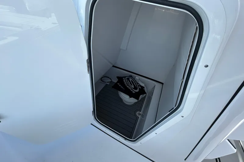 Slide: The Image of 2026 Sportsman Masters 267OE Bay Boat interior storage compartment with open door. - 5