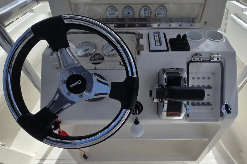 Slide: The Image of 1998 Fountain 25 Center Console boat dashboard with steering wheel and controls. - 16